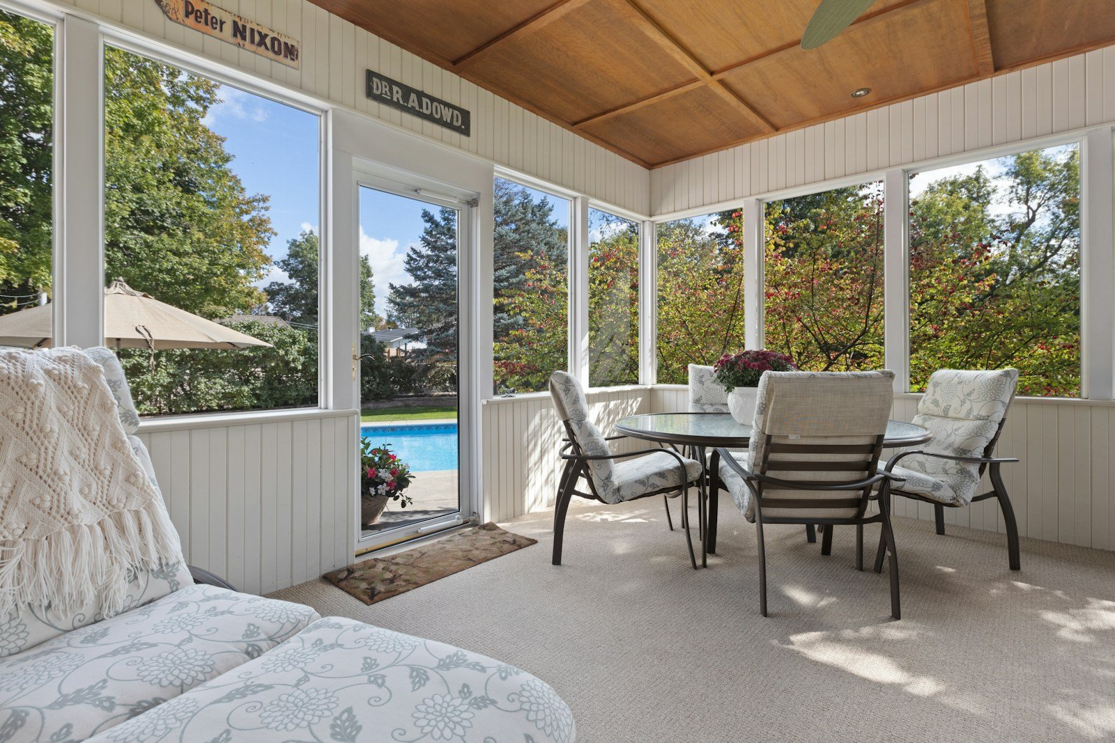 A sunroom interior with a sliding glass door looking out to a backyard.